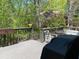 Wooden outdoor deck with seating, grill, and views of a lush green space at 1801 Summerview Ct, Woodstock, GA 30189
