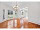 Bright dining room with hardwood floors, bay window with shutters, and elegant chandelier at 1801 Summerview Ct, Woodstock, GA 30189