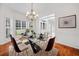 Bright dining room boasts a modern glass table, chandelier, and natural light from plantation-shuttered windows at 1801 Summerview Ct, Woodstock, GA 30189