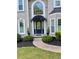 Detailed view showcasing the front door, covered entrance, and manicured landscaping at 1801 Summerview Ct, Woodstock, GA 30189