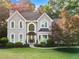 Charming two-story home featuring arched windows, a covered entrance, and mature landscaping at 1801 Summerview Ct, Woodstock, GA 30189