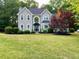 Charming two-story home with a well-manicured lawn, mature trees, and impeccable landscaping at 1801 Summerview Ct, Woodstock, GA 30189