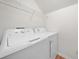 Bright laundry area with washer and dryer featuring overhead shelving, great for optimizing space at 1801 Summerview Ct, Woodstock, GA 30189