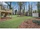 Expansive grassy backyard featuring a shed, deck, and mature trees providing an ideal outdoor space at 3414 Dearwood Sw Dr, Lilburn, GA 30047