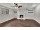 Spacious basement area with a brick fireplace, floating shelves, ceiling fan, and a window at 3414 Dearwood Sw Dr, Lilburn, GA 30047