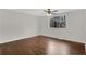 Empty bedroom showcasing wood floors, neutral walls, a ceiling fan, and a large window for natural light at 3414 Dearwood Sw Dr, Lilburn, GA 30047