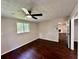 Bedroom featuring modern ceiling fan, wood-look floors, and natural light from the window at 3414 Dearwood Sw Dr, Lilburn, GA 30047
