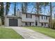 Charming two-story home with a gray exterior, a long driveway, and a one car garage at 3414 Dearwood Sw Dr, Lilburn, GA 30047