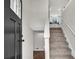 Inviting foyer showcasing a staircase with carpeted steps and a view into the kitchen with white cabinets at 3414 Dearwood Sw Dr, Lilburn, GA 30047
