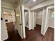 Hallway with open doors to rooms, showcasing dark wood-look floors throughout the basement at 3414 Dearwood Sw Dr, Lilburn, GA 30047
