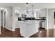 Modern kitchen boasts white cabinets, black backsplash, stainless steel appliances, and a center island at 3414 Dearwood Sw Dr, Lilburn, GA 30047
