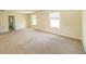 A bedroom featuring neutral carpet, a window, and an entry way at 4420 Merrigold Way, Fairburn, GA 30213