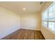 Bright bedroom featuring wood-look flooring, a window, neutral paint, and molding details at 4420 Merrigold Way, Fairburn, GA 30213
