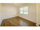 Bedroom features wood-look flooring, neutral paint, bright natural light, and classic molding details at 4420 Merrigold Way, Fairburn, GA 30213