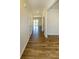 Hallway with wood-look flooring provides an open and airy entryway with doors leading to various rooms at 4420 Merrigold Way, Fairburn, GA 30213