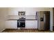 A modern kitchen features stainless steel appliances, white cabinetry, and granite countertops with subway tile backsplash at 4420 Merrigold Way, Fairburn, GA 30213