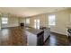 Open-concept living room features hardwood floors, a fireplace, and a kitchen island with a double sink at 4420 Merrigold Way, Fairburn, GA 30213