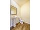 Cozy powder room with wood-look flooring, a pedestal sink, and a modern mirror at 4420 Merrigold Way, Fairburn, GA 30213