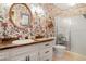 Bathroom featuring a shower with glass doors, floral wallpaper, and a vanity with storage at 850 John Alden Rd, Stone Mountain, GA 30083