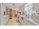 Bright white kitchen featuring ample cabinet space, tile flooring, and a window view to the backyard at 850 John Alden Rd, Stone Mountain, GA 30083