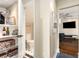 View of hallway, powder room with black and white tile, built-in shelves, and open living area with wood flooring at 1071 Standard Ne Dr, Brookhaven, GA 30319