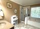 Modern bathroom with tub, separate glass shower, tiled floors, and towel rack at 2674 Misty Rock Cv, Dacula, GA 30019