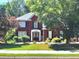 Charming two-story brick home featuring lush landscaping, a manicured lawn, and a welcoming front entrance at 2674 Misty Rock Cv, Dacula, GA 30019