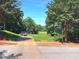 Golf course view with vibrant green fairway, mature trees and golf carts near the Tee at 2674 Misty Rock Cv, Dacula, GA 30019