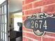 Close-up of house number 2674 on a brick wall next to a glimpse of the home's interior at 2674 Misty Rock Cv, Dacula, GA 30019