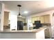 Open kitchen with light wood cabinets, stainless steel appliances, tile backsplash, and bright lighting at 2674 Misty Rock Cv, Dacula, GA 30019