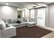 Living room with a gray sectional sofa, brown rug, and doorway at 2674 Misty Rock Cv, Dacula, GA 30019