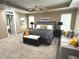 Spacious bedroom with a king bed, sitting area, tray ceilings, and a neutral color palette at 2674 Misty Rock Cv, Dacula, GA 30019