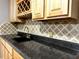 Close up of a wet bar with black granite countertops and custom tile backsplash at 2674 Misty Rock Cv, Dacula, GA 30019
