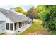 Home's rear exterior with a sunroom, a stone chimney, and a well-maintained lawn at 507 Huntgate Rd, Woodstock, GA 30189