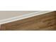 Close up of dark, laminate flooring with white trim at 507 Huntgate Rd, Woodstock, GA 30189