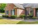 Charming brick home with lush landscaping, green lawn, and mature hedges at 507 Huntgate Rd, Woodstock, GA 30189