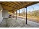 Covered back patio with concrete flooring, providing a shaded outdoor living space with a view of the wooded lot at 846 Brandy Oaks Ln, Stone Mountain, GA 30088