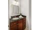 Bathroom featuring granite counters, dark wood cabinets, and a decorative mirror at 325 E Paces Ferry Ne Rd # 410, Atlanta, GA 30305