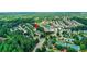 Aerial view of the neighborhood featuring community swim and tennis amenities, surrounded by mature trees and lush landscaping at 3980 Suwanee Place Dr, Suwanee, GA 30024
