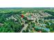 Aerial view of the neighborhood featuring community swim and tennis amenities, surrounded by mature trees and lush landscaping at 3980 Suwanee Place Dr, Suwanee, GA 30024