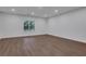 Finished basement features wood floors, ample lighting, and neutral color palette at 3980 Suwanee Place Dr, Suwanee, GA 30024