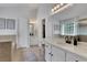 Bright bathroom featuring double sinks with marble countertops, a large mirror, and a walk-in closet at 3980 Suwanee Place Dr, Suwanee, GA 30024