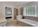 Bathroom showcasing a soaking tub and a separate glass-enclosed shower, next to a bedroom at 3980 Suwanee Place Dr, Suwanee, GA 30024