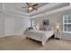 Bedroom with tray ceiling, two nightstands, carpet, neutral colors, and two windows at 3980 Suwanee Place Dr, Suwanee, GA 30024