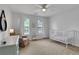 Bright bedroom with a crib, fan and a dresser with a mirror at 3980 Suwanee Place Dr, Suwanee, GA 30024