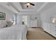 Bedroom with tray ceiling, two dressers, carpet and neutral colors at 3980 Suwanee Place Dr, Suwanee, GA 30024