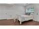 Well lit bedroom with wood floors, neutral color palette, and an accent chair at 3980 Suwanee Place Dr, Suwanee, GA 30024
