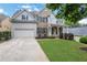 Charming home with a well-manicured lawn, beautiful landscaping, and a two-car garage at 3980 Suwanee Place Dr, Suwanee, GA 30024