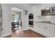 Well-appointed kitchen with white cabinets and stainless steel appliances, next to dining room at 3980 Suwanee Place Dr, Suwanee, GA 30024