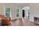 Bright living room with hardwood floors, a comfortable leather chair, and plenty of natural light at 3980 Suwanee Place Dr, Suwanee, GA 30024